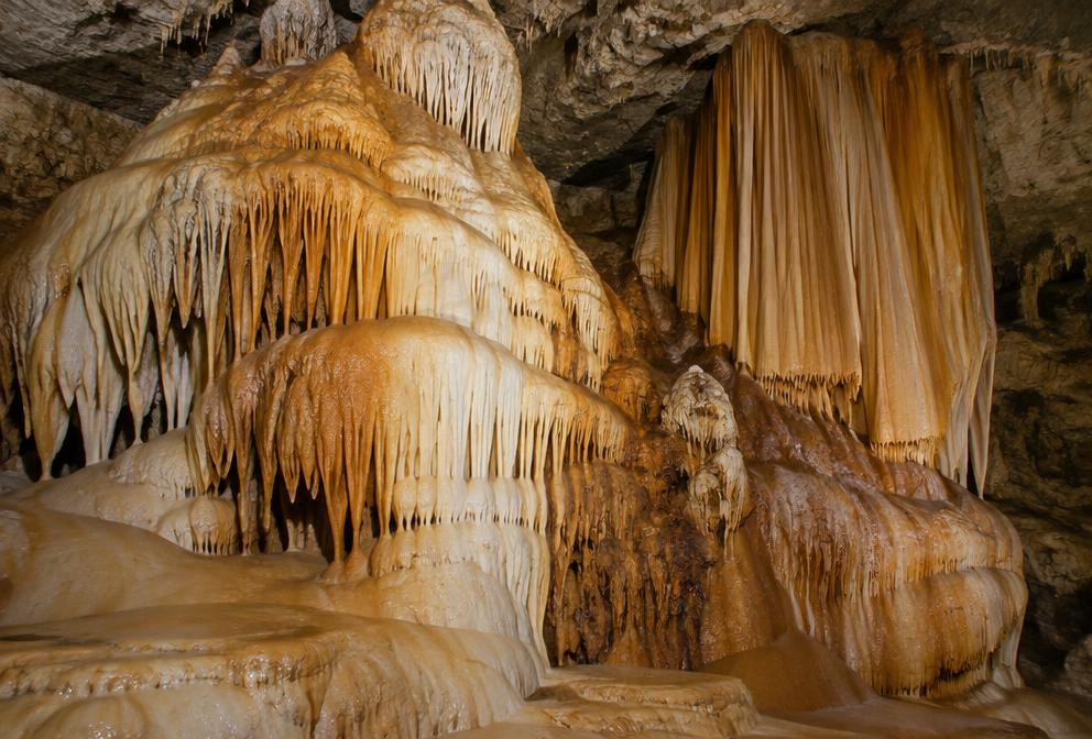 Flowstone formations resembling frozen waterfalls and curtains